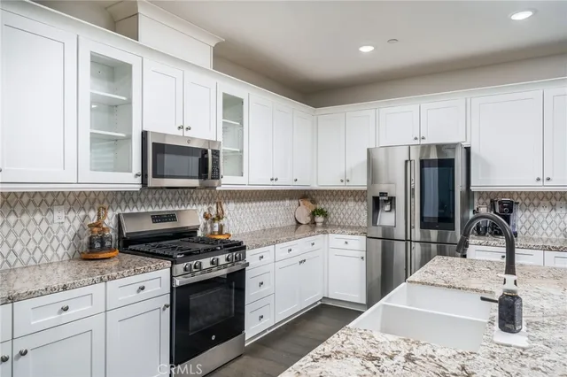 a kitchen with white cabinets sink and stainless steel appliances