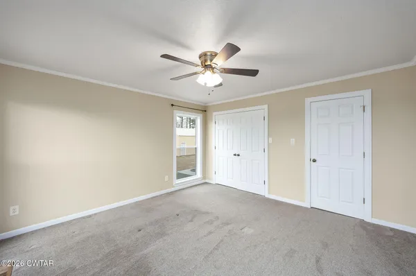 a view of a room with a ceiling fan and a window