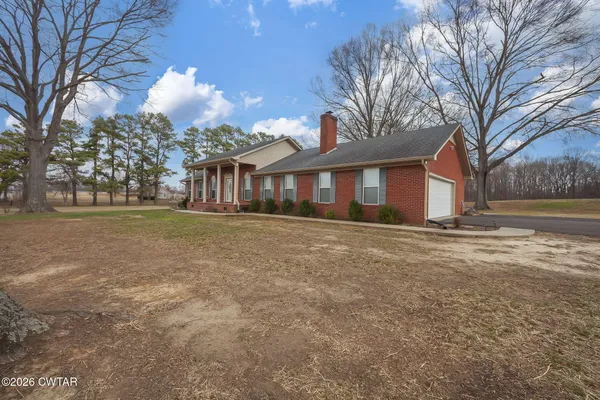a front view of house with yard and trees around