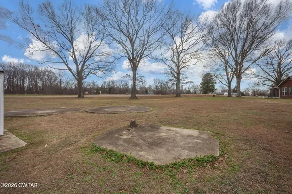 a view of dirt field with trees