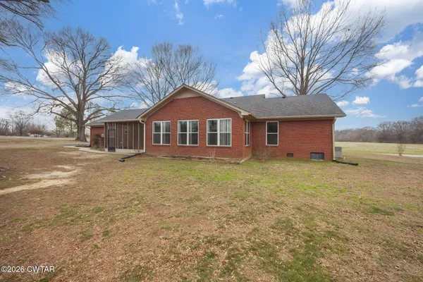 a front view of a house with a garden and trees