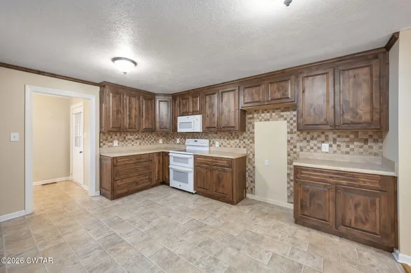 a kitchen with granite countertop a sink cabinets stainless steel appliances and a window