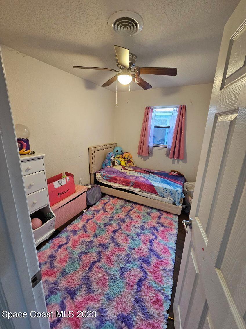 4045 Edwards Street Melbourne, FL 32901 - Photo 11 of 19 a bedroom with a bed and a chandelier