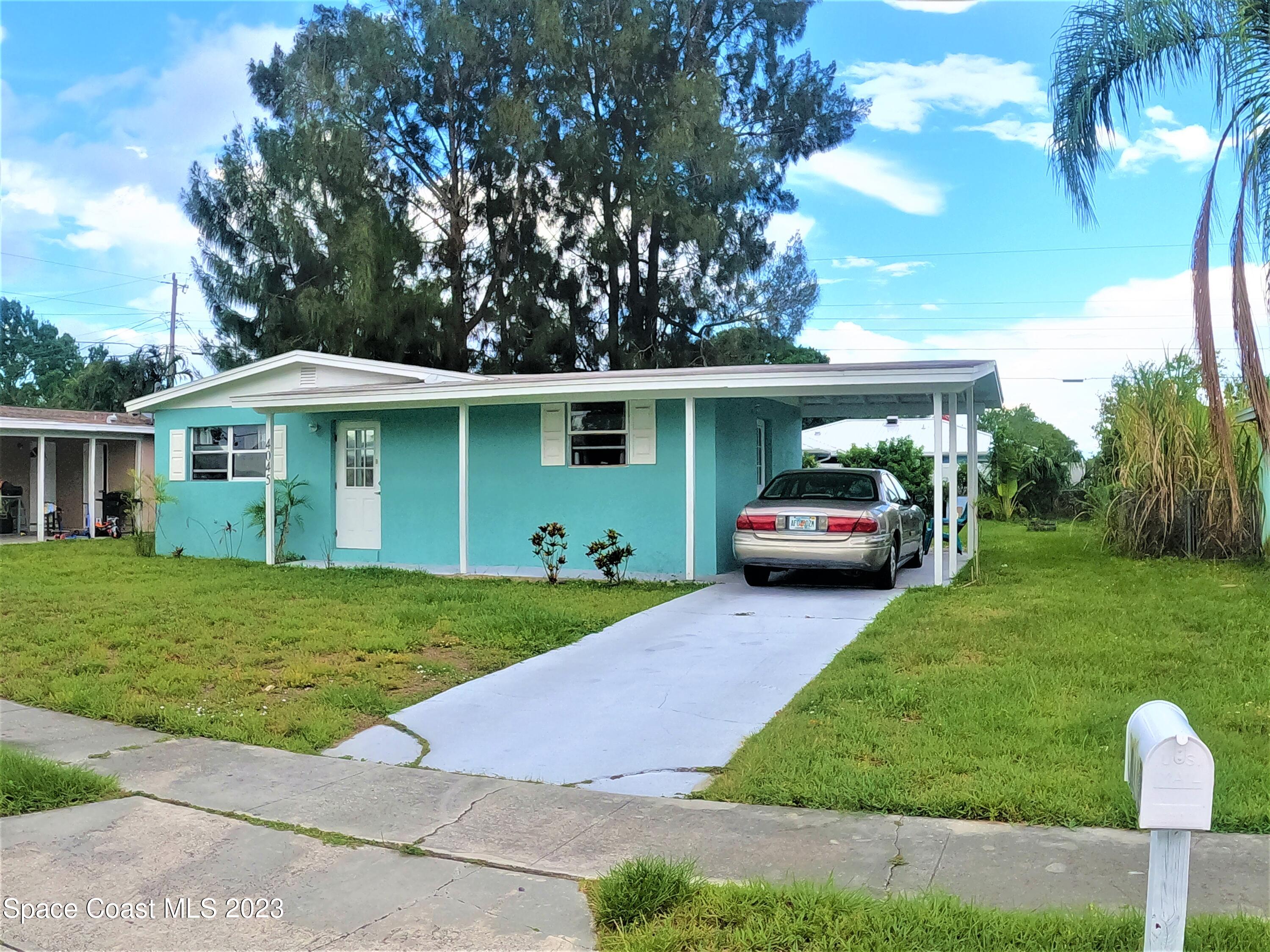 4045 Edwards Street Melbourne, FL 32901 - Photo 3 of 19 a front view of a house with a garden