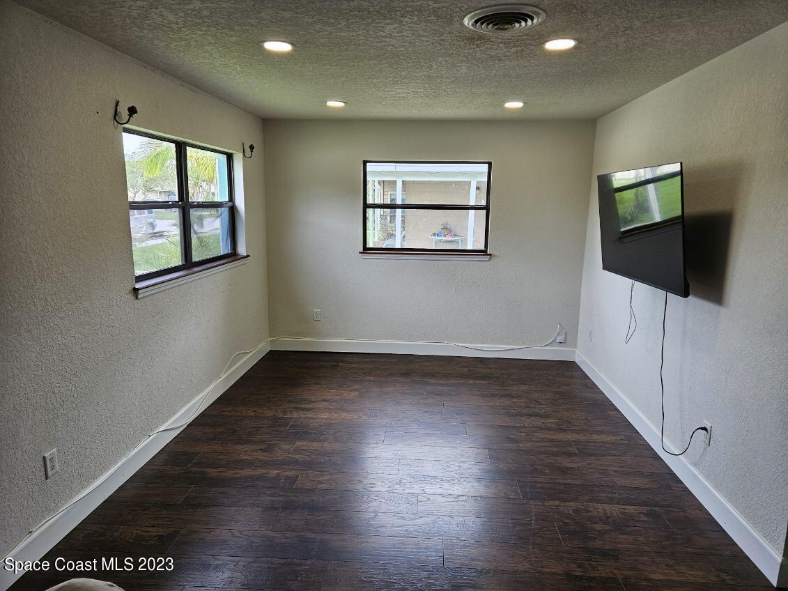 4045 Edwards Street Melbourne, FL 32901 - Photo 6 of 19 an empty room with wooden floor and windows