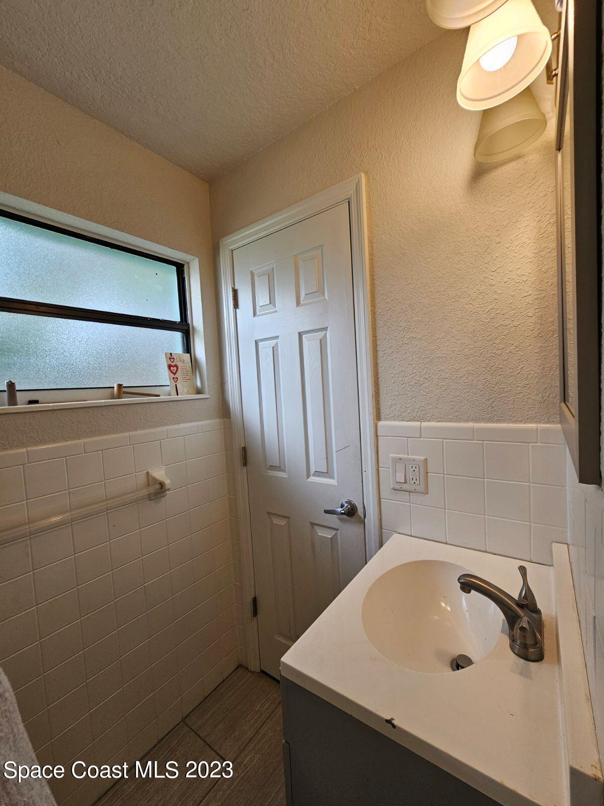 4045 Edwards Street Melbourne, FL 32901 - Photo 8 of 19 a bathroom with a sink and a tub