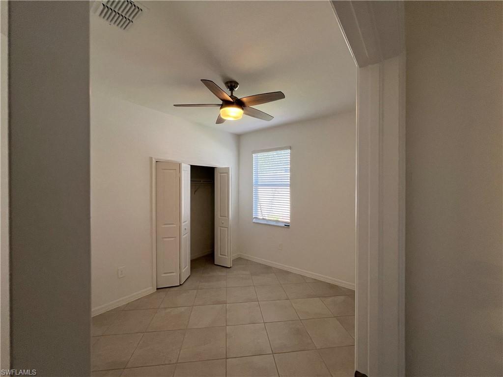 2320 Dragonfruit Way Naples, FL 34120 - Photo 11 of 33 Unfurnished bedroom with light tile patterned floors, a closet, a ceiling fan, visible vents, and baseboards
