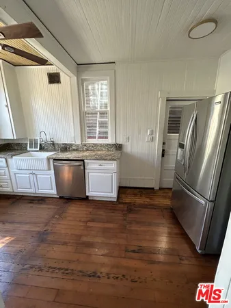 a view of a kitchen with wooden floor and electronic appliances