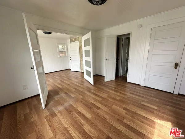 an empty room with wooden floor and closet