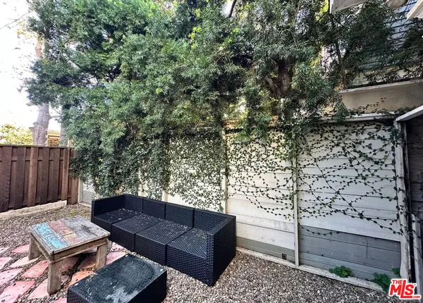 a view of a patio with table and chairs with wooden fence