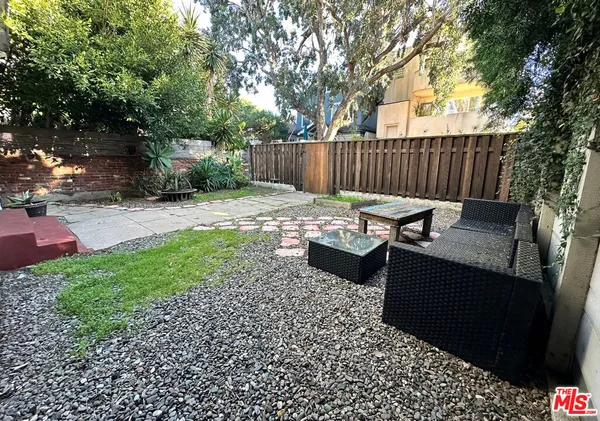 a view of backyard with wooden fence and a large tree
