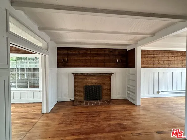 a living room with a fireplace and a wooden floor