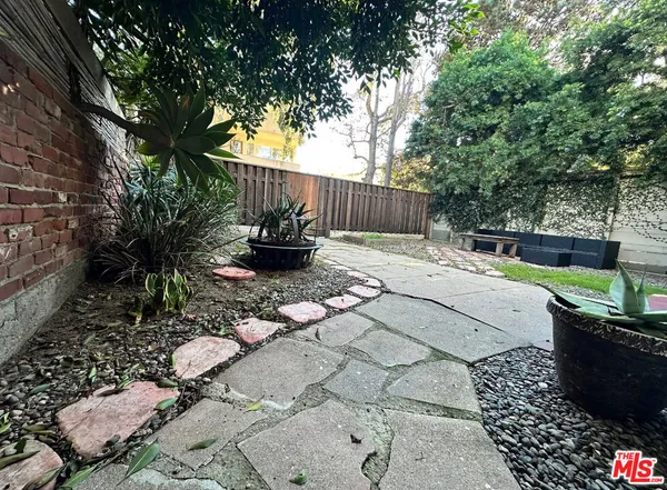 a view of a backyard with plants and a patio