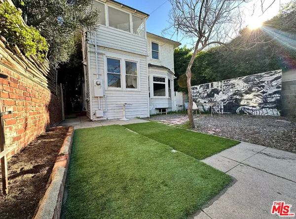a view of a backyard with chair and potted plants