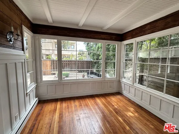 a view of lot of an empty room with a window and wooden floor