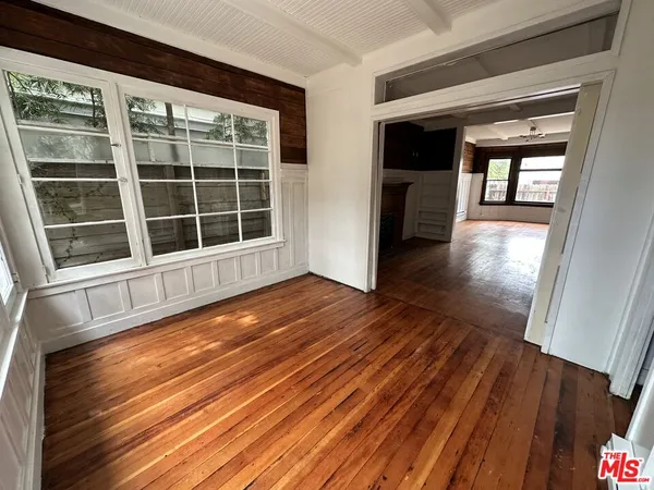 a view of empty room with wooden floor and windows