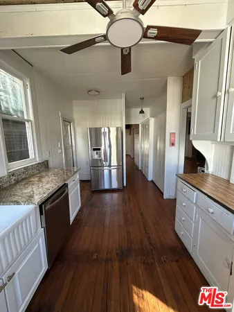 a large kitchen with stainless steel appliances granite countertop a lot of counter space and wooden floor