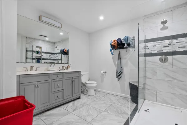 a bathroom with a double vanity sink mirror and shower