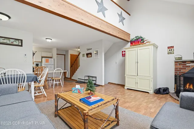a living room with furniture a flat screen tv and a table