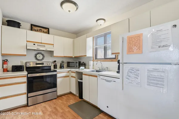 a kitchen with granite countertop cabinets stainless steel appliances and a sink