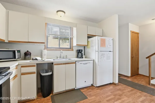 a kitchen with refrigerator a stove a sink and a window