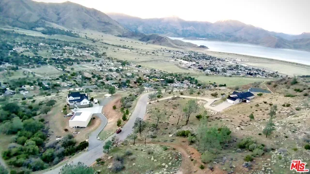 an aerial view of house with yard and mountain view in back