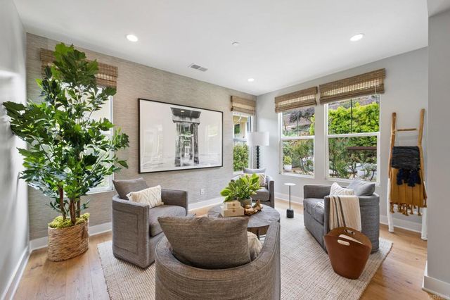 a living room with furniture potted plant and a large window