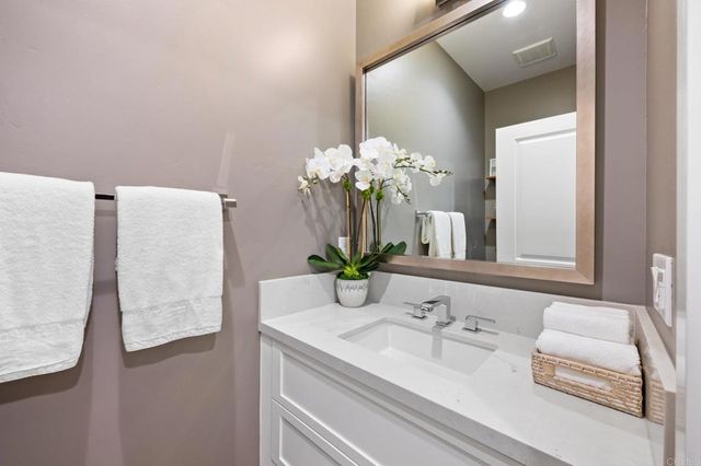 a bathroom with a granite countertop sink a toilet and a mirror