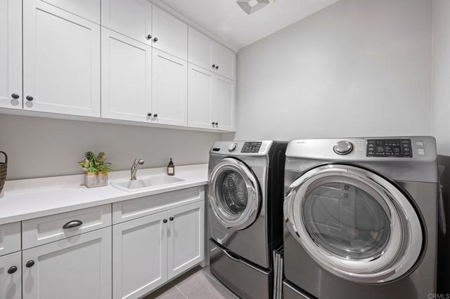 a utility room with sink dryer and washer