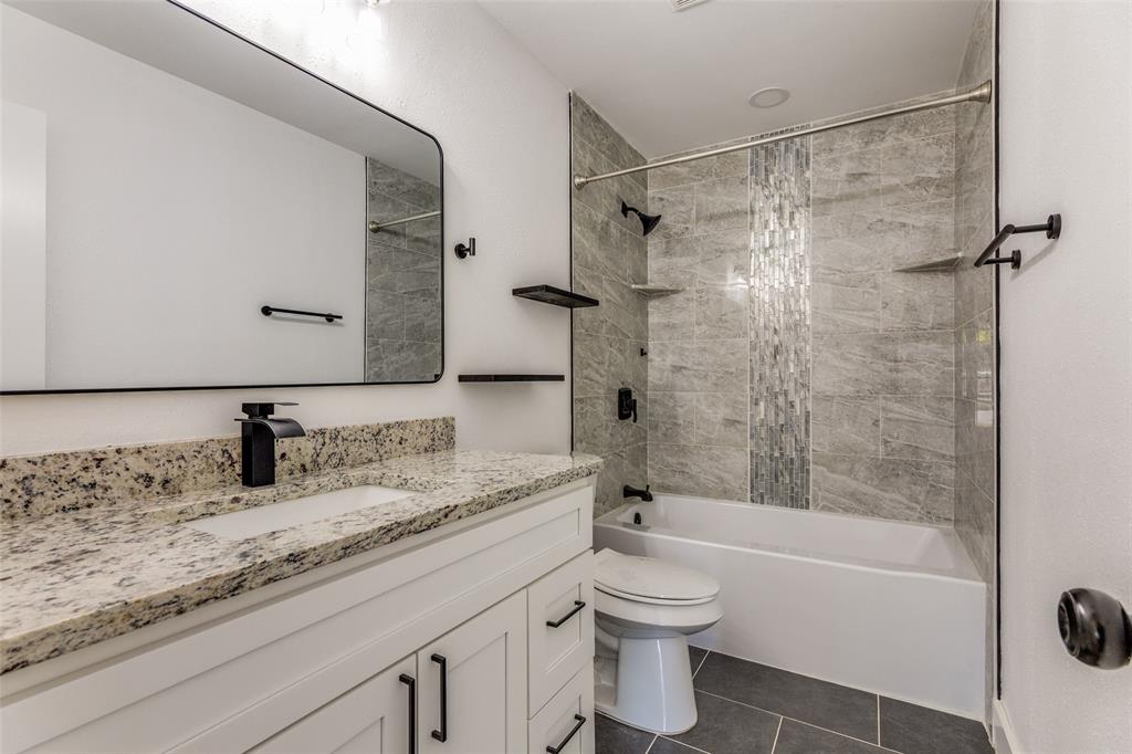 6617 Starnes Road Watauga, TX 76148 - Photo 16 of 22 a bathroom with a granite countertop sink toilet and shower