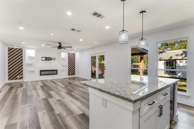 a kitchen that has a lot of cabinets in it and wooden floors
