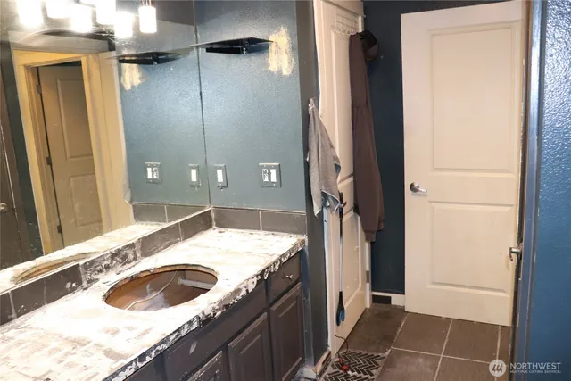 a bathroom with a granite countertop sink a toilet and shower