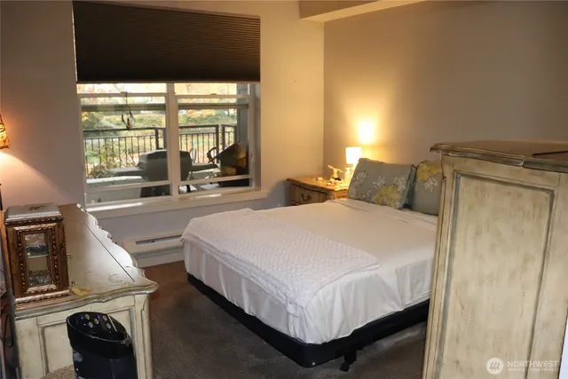 a bedroom with a bed and large windows