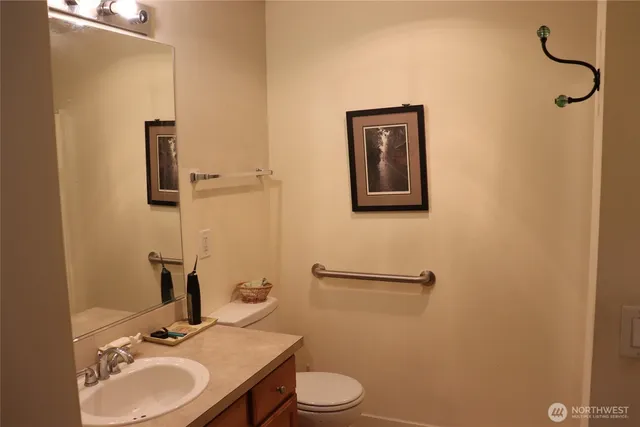 a bathroom with a granite countertop sink toilet and a mirror