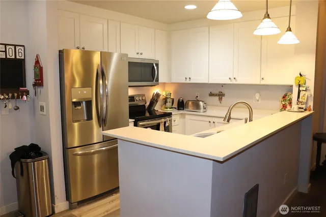 a kitchen with stainless steel appliances a refrigerator sink and microwave