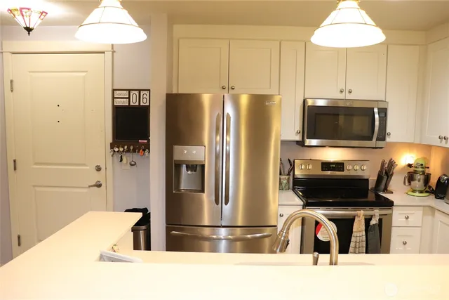 a kitchen with stainless steel appliances a refrigerator a stove a microwave and cabinets