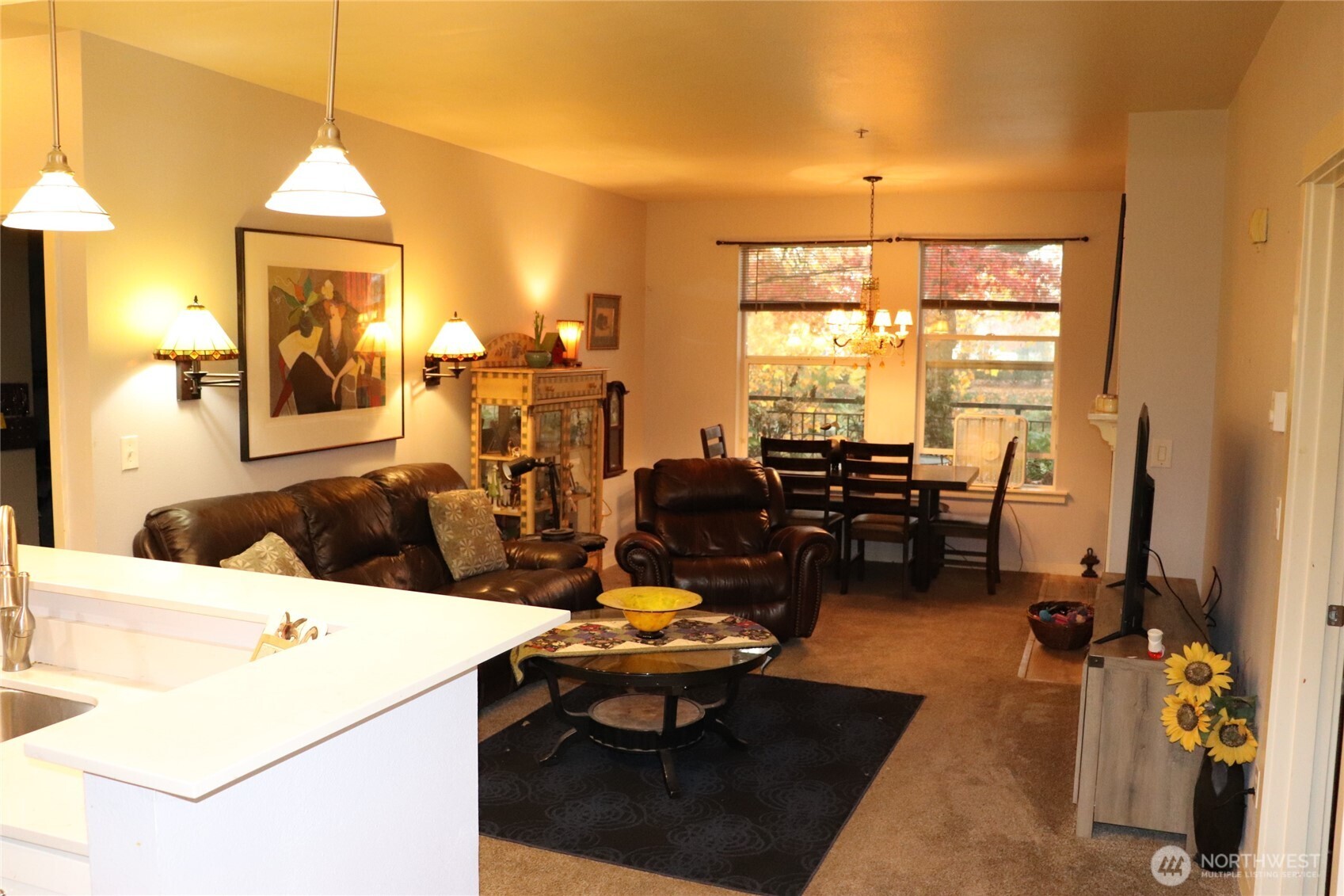 55 Williams Avenue South, Unit 104 Renton, WA 98057 - Photo 6 of 22 a living room with furniture a rug and a chandelier