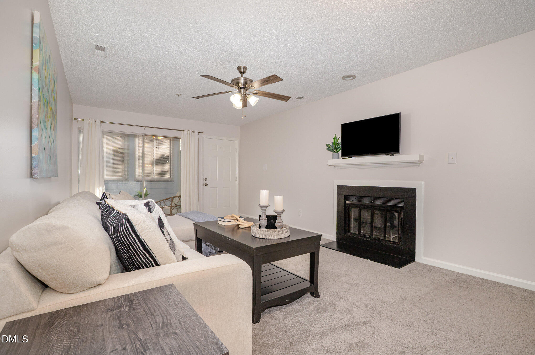 4911 Hollenden Drive, Unit 108 Raleigh, NC 27616 - Photo 5 of 19 a living room with furniture a fireplace and a flat screen tv
