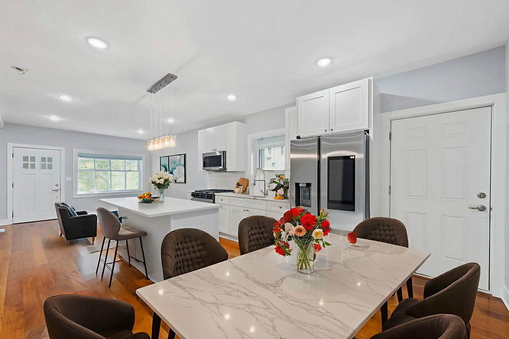 13518 South Ave K Chicago, IL 60633 - Photo 10 of 24 a kitchen with stainless steel appliances kitchen island granite countertop a dining table chairs and white cabinets
