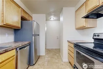 a kitchen with stainless steel appliances granite countertop a refrigerator and a stove