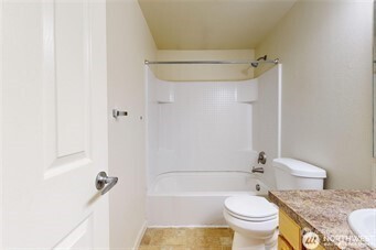 1928 J Street, Unit 205 Walla Walla, WA 99362 - Photo 8 of 20 a bathroom with a granite countertop toilet a sink and shower