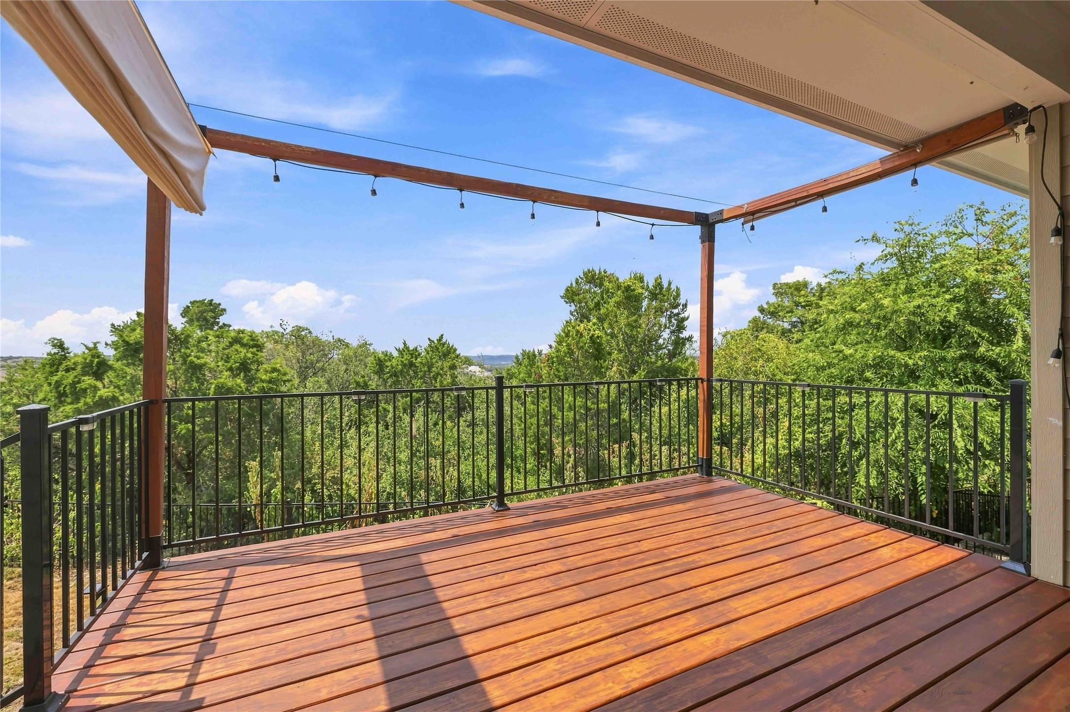 1722 Rowdy Loop, Unit 7 Leander, TX 78641 - Photo 24 of 37 Spacious deck with elegant railing offers serene views of lush greenery, perfect for outdoor relaxation and entertainment.