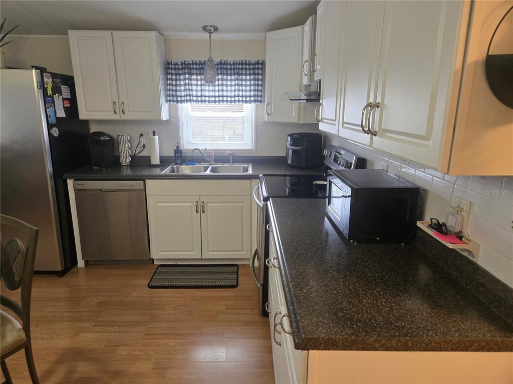 1710 7th Street Southwest, Unit 93 Ruskin, FL 33570 - Photo 13 of 38 a kitchen with stainless steel appliances granite countertop a stove a sink a refrigerator and white cabinets