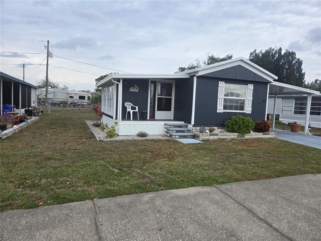 1710 7th Street Southwest, Unit 93 Ruskin, FL 33570 - Photo 2 of 38 a front view of a house with a yard outdoor seating and garage