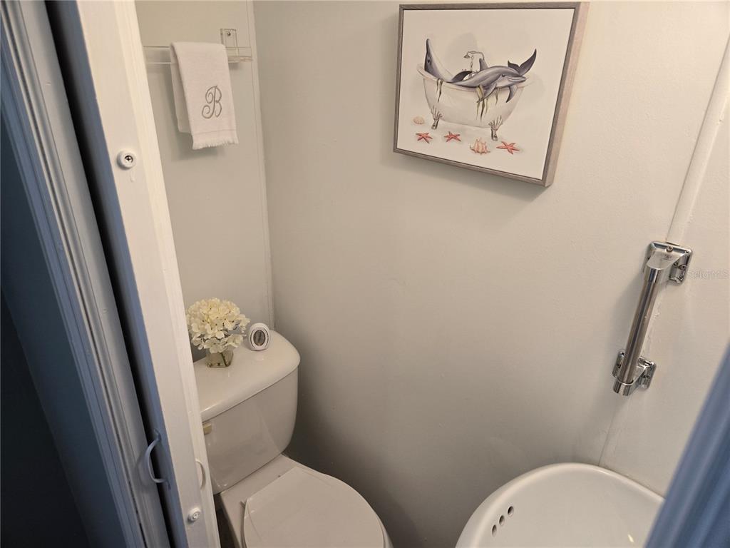 1710 7th Street Southwest, Unit 93 Ruskin, FL 33570 - Photo 24 of 38 a white toilet sitting next to a bathroom sink and vanity