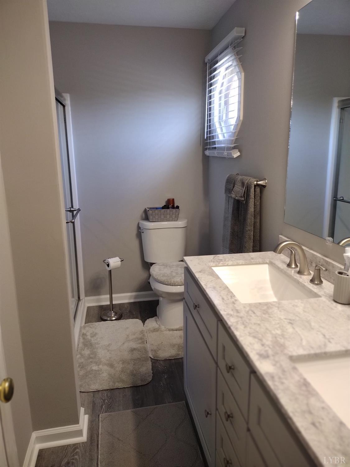 4499 Stage Road Concord, VA 24538 - Photo 30 of 64 a bathroom with a granite countertop sink a toilet and a mirror