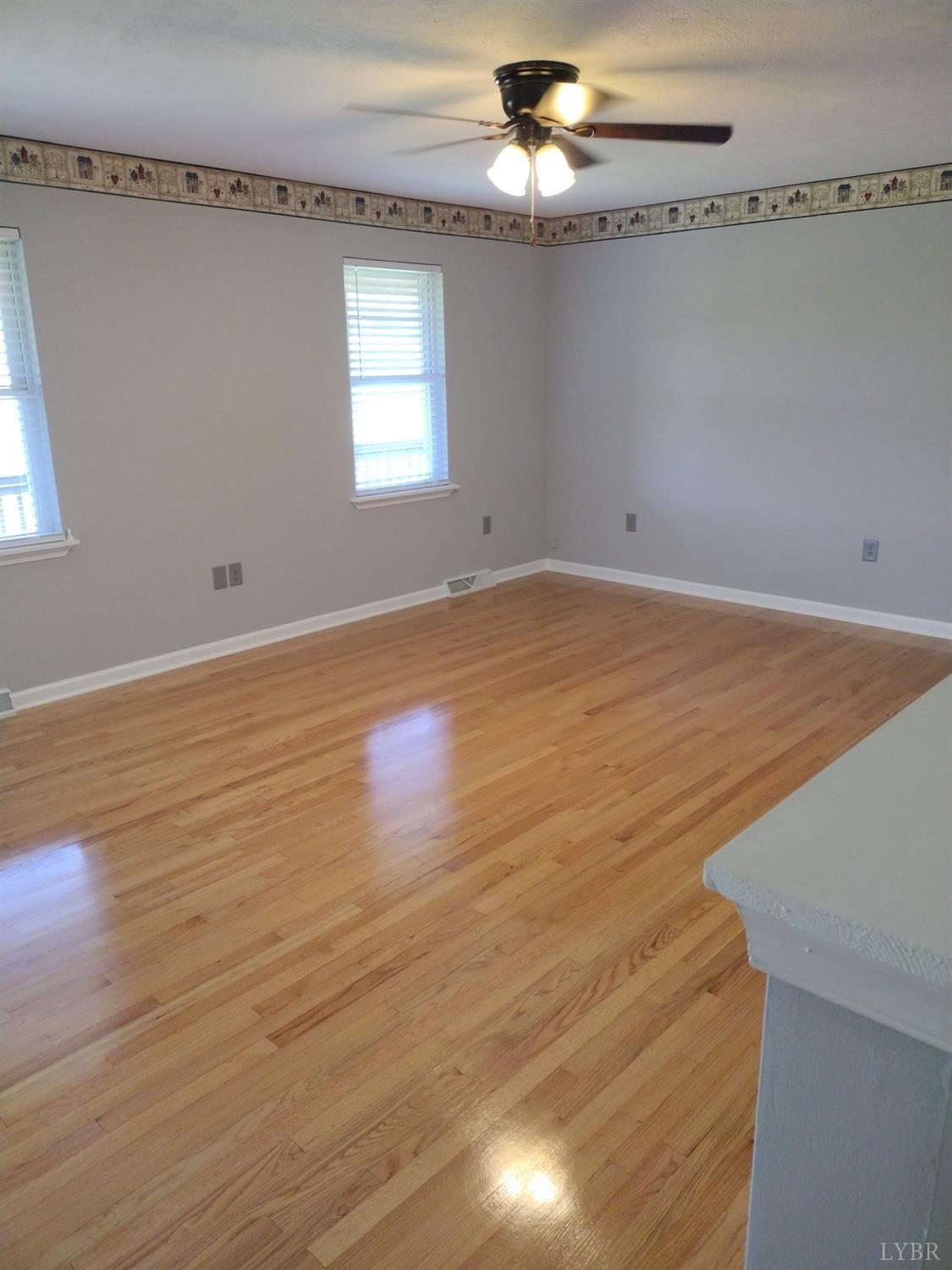 4499 Stage Road Concord, VA 24538 - Photo 9 of 64 an empty room with wooden floor chandelier fan and windows