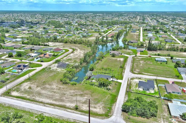 an aerial view of a residential houses with outdoor space and street view