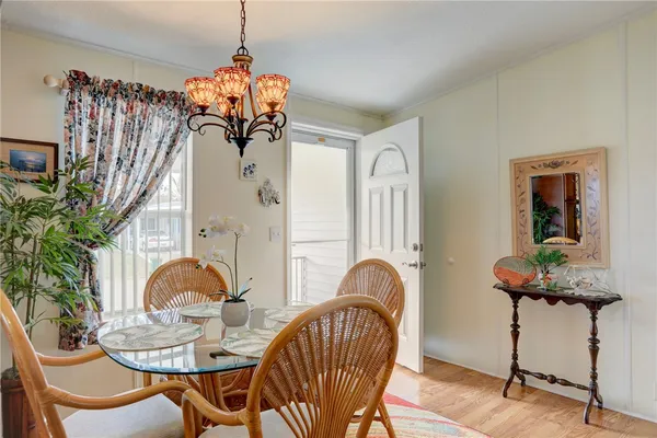a dining room with furniture potted plants and wooden floor
