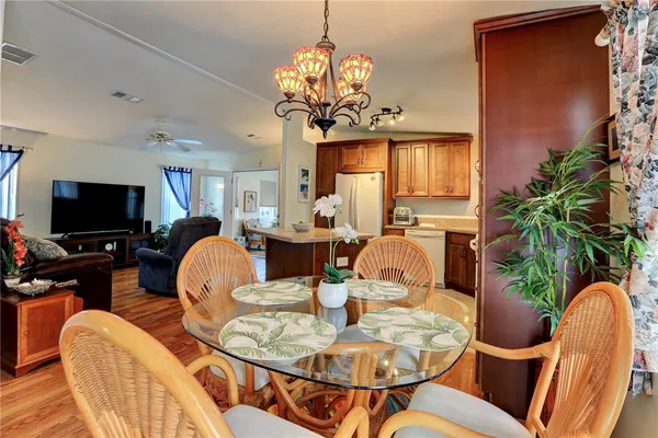 a view of a dining room with furniture a chandelier and wooden floor